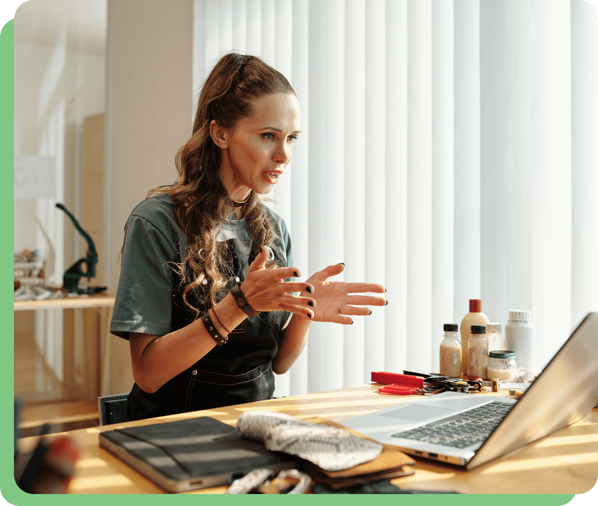 Woman gesturing while video calling on laptop.