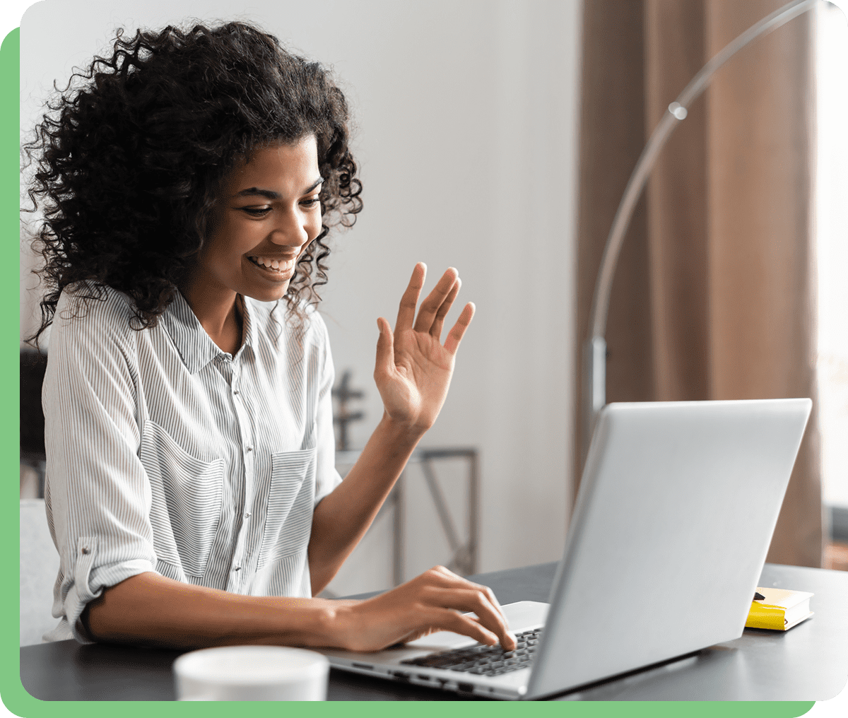 Smiling woman video chatting on laptop.