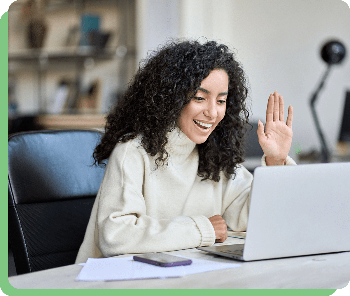 Woman waving during a video call meeting.